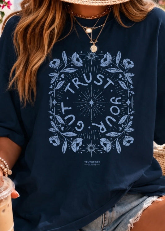Person wearing a navy blue sweatshirt with a motivational quote design. Text says 'trust your gut'.