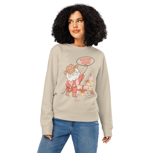 Woman wearing beige organic sweatshirt with a cowboy Santa Claus graphic and 'Western Wishes' text on a white background.