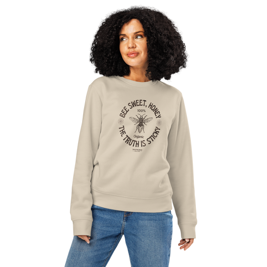 Woman wearing beige organic sweatshirt with bee and text ' Bee sweet, honey, the truth is sticky' design on a white background