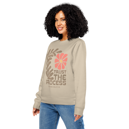 woman wering beige organic sweatshirt with floral design and 'Trust The Process' text