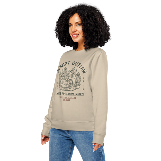 Woman wearing beige organic sweatshirt with 'Desert Outlaw, where freedom rides' text and graphic design of cowboy riding a broco in the desert, on a white background