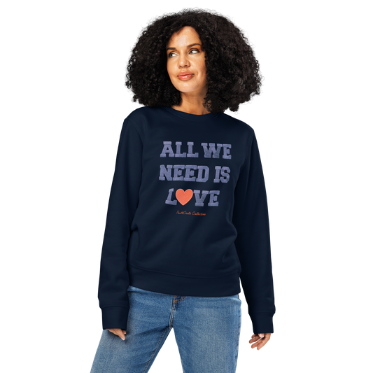Woman wearing navy blue organic sweatshirt with 'All We Need Is Love' text on a white background