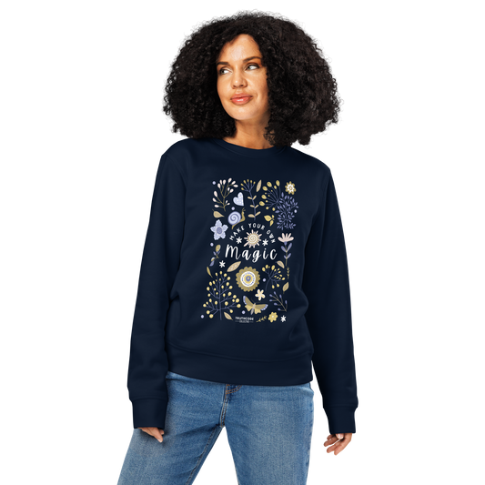 Woman wearing navy blue organic sweatshirt with floral design and text 'Make your own magic' on a white background