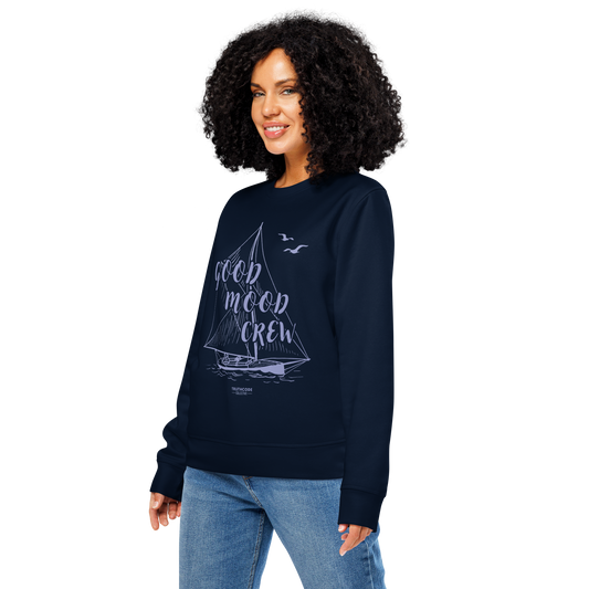 Woman wearing navy blue organic sweatshirt with sailboat graphic and 'Good Mood Crew' text on a white background