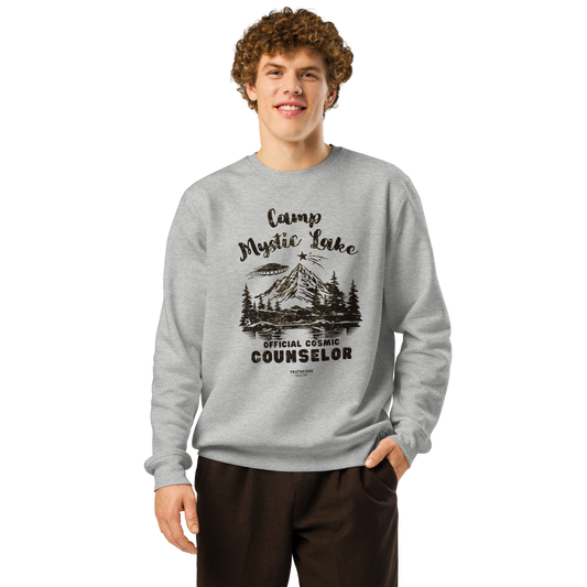 Guy wearing gray organic sweatshirt with mountain scene and spaceship graphic design and text 'Camp Mystic Lake, official cosmic counselor' on a white background