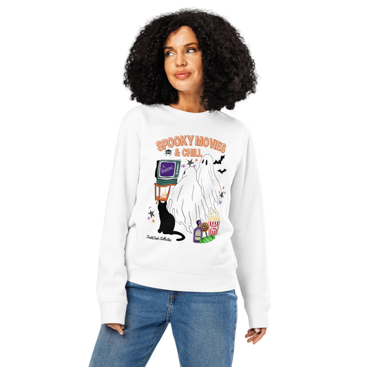 Woman wearing white organic sweatshirt with Halloween-themed design featuring a ghost, black cat, TV, and popcorn and text 'Spooky movies and chill' on a white background