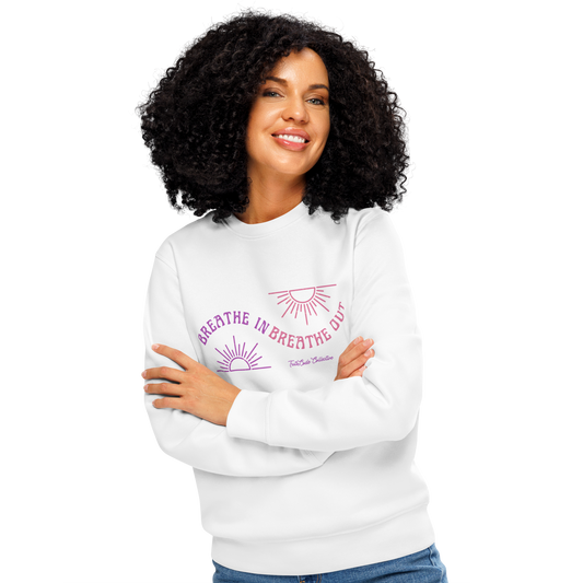 Woman wearing white organic sweatshirt with pink and purple sun design and text 'Breathe in breathe out' on a white background