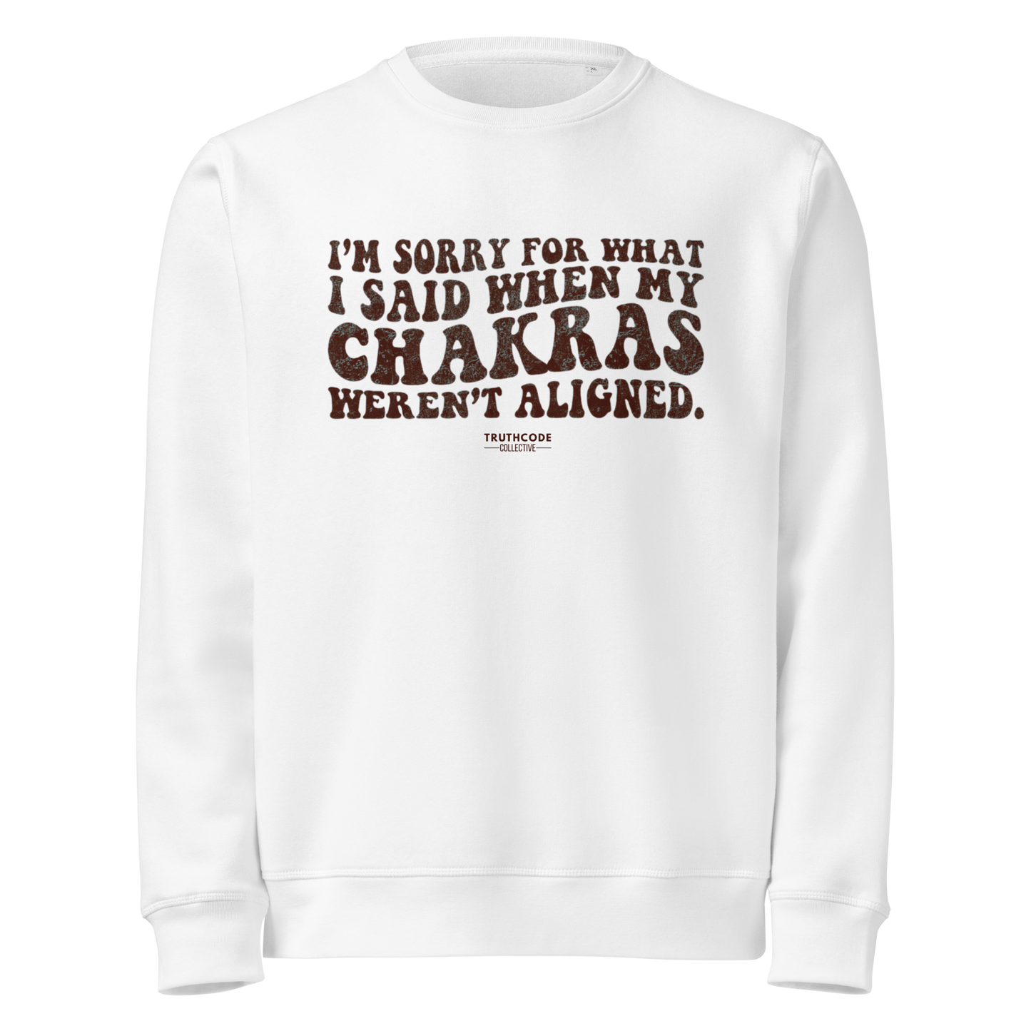 White organic sweatshirt with humorous text 'I'm sorry for what I said when my chakras weren't aligned' on a white background