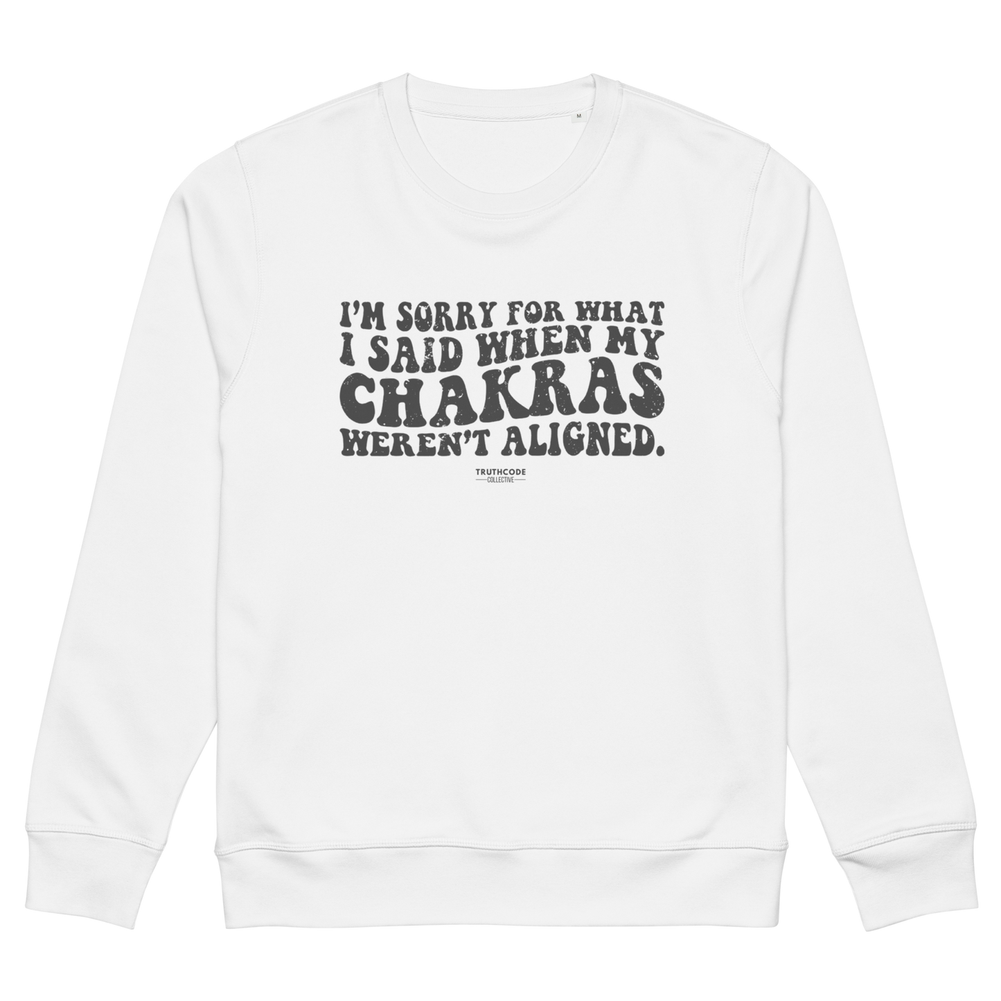 White organic sweatshirt with humorous text design 'I'm sorry for what I said when my chakras weren't aligned' on a white background