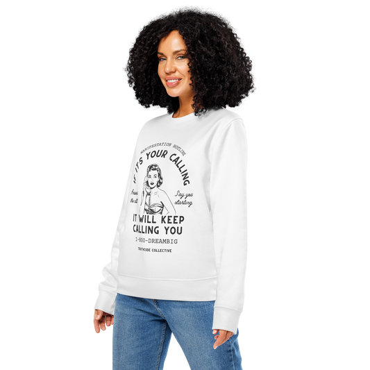 Woman wearing white organic sweatshirt with vintage-style graphic of woman on the phone and text 'If it's your calling, it will keep calling you', on a white background