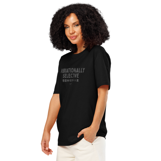 Woman wearing black organic t-shirt with text 'Vibrationally selective' on a white background