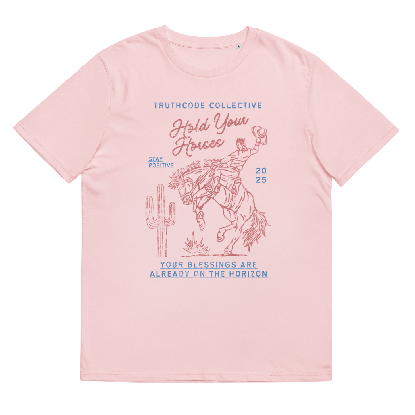 Pink organic t-shirt with cowboy on a bucking bronco and cactus graphic design and text 'Hold your horses, your blessings are on the horizon' on a white background