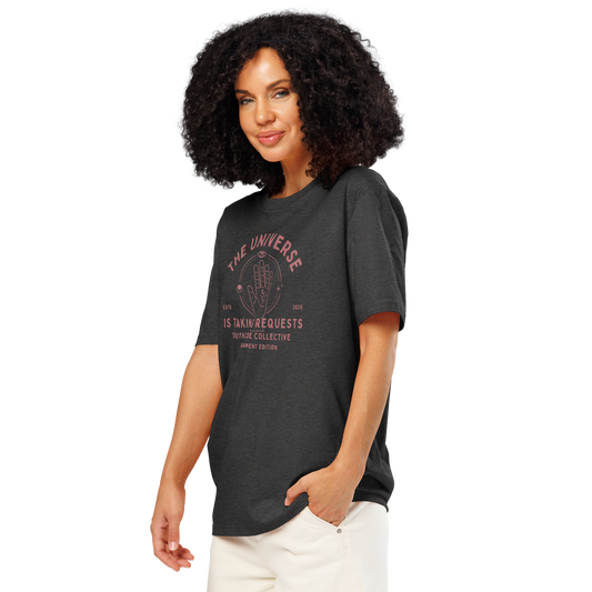 Woman wearing dark gray organic t- shirt with astrological style graphic of a hand with text reading ' The universe is taking requests'