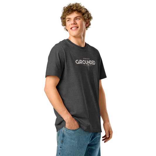 Man wearing gray organic t-shirt with 'GROUNDED' text and tree root graphic extending down
