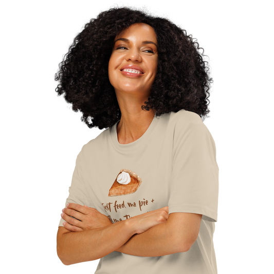 Woman wearing beige organic t-shirt with a pie graphic and text 'Just feed me pie + tell me I'm pretty'