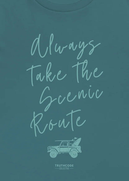 Close view of teal t-shirt with 'Always Take the Scenic Route' text and car graphic on a teal background