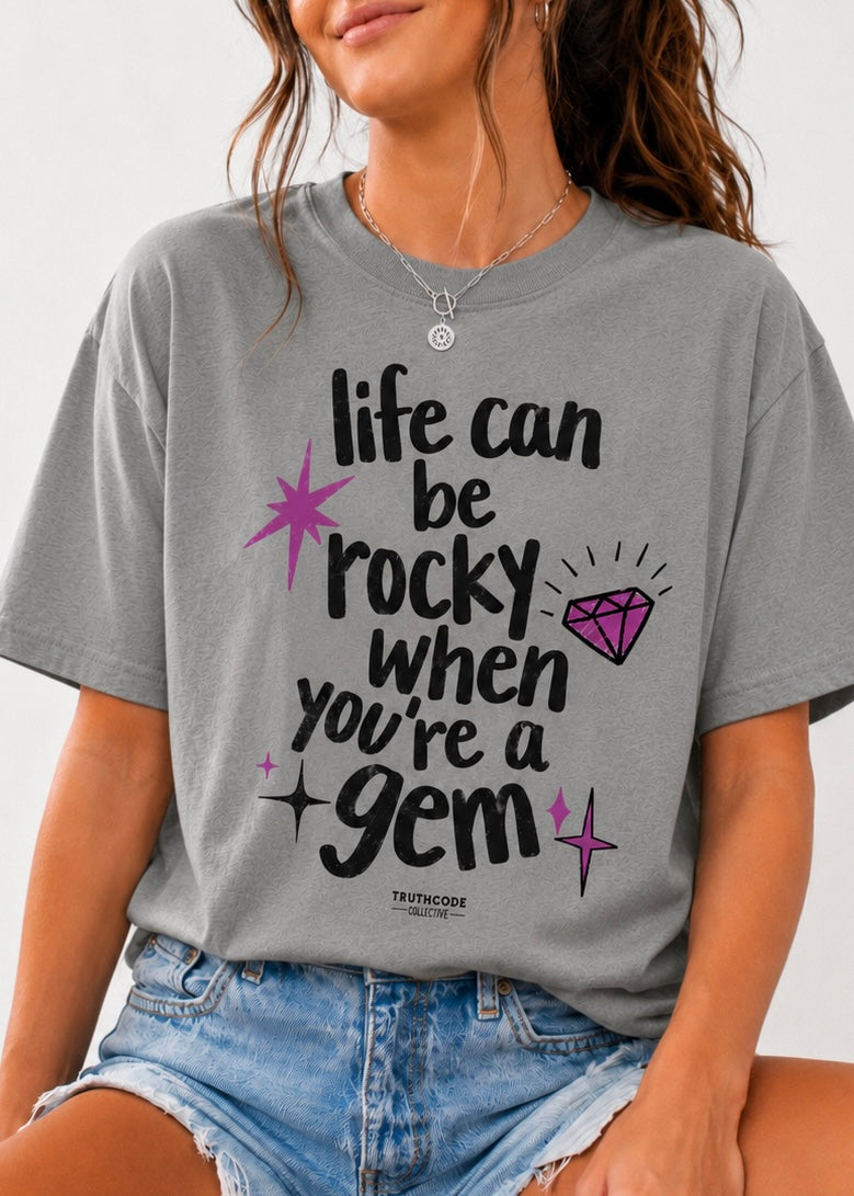 Person wearing a gray t-shirt with a motivational quote and graphic design.