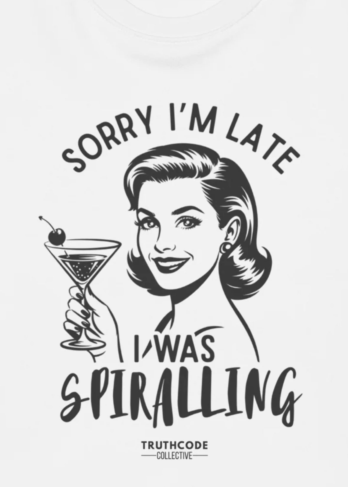 Close view of white sweatshirt with vintage-style illustration of a woman holding a martini with text 'Sorry I'm late, I was spiralling' 