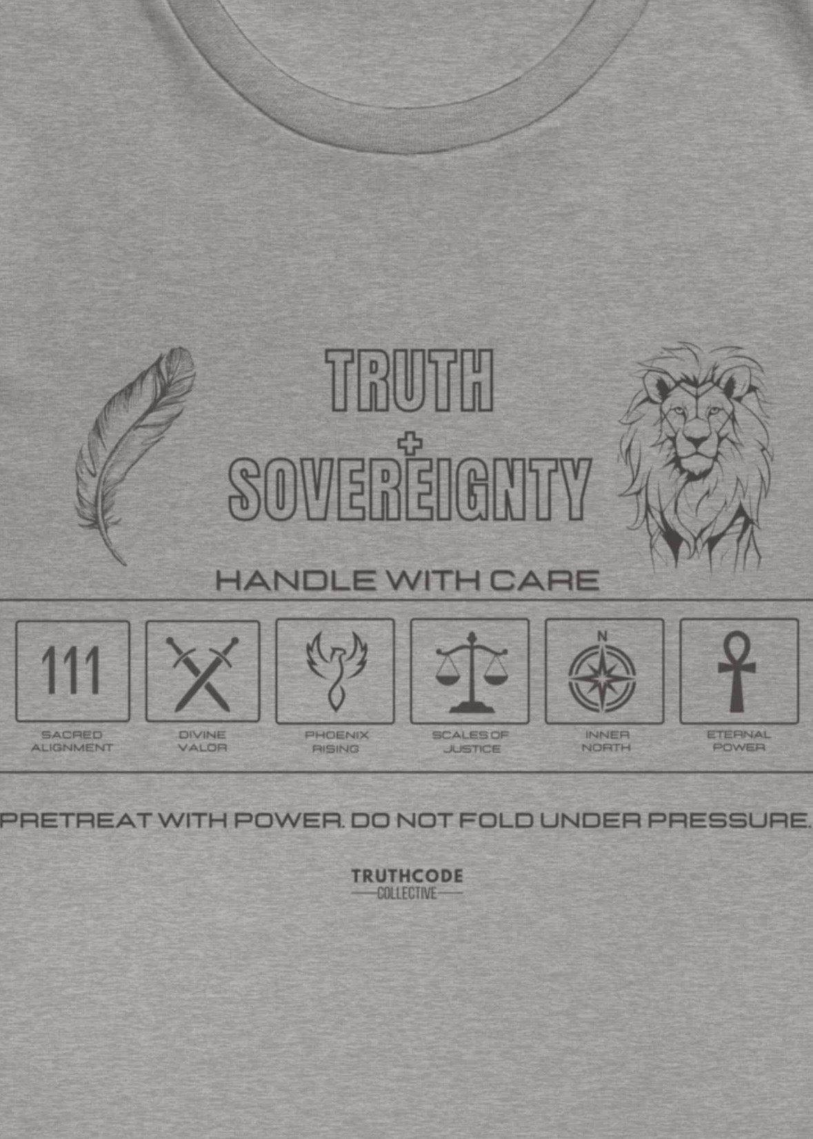 Close view of gray t-shirt with text 'Truth + Sovereignty' and 'Pretreat with power do not fold under pressure' and laundry tag inspired design with symbols relating to it
