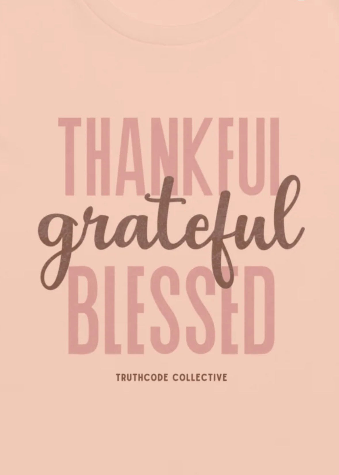 Peach t-shirt with motivational quote 'Thankful, grateful, blessed' and 'Truthcode Collective' branding.