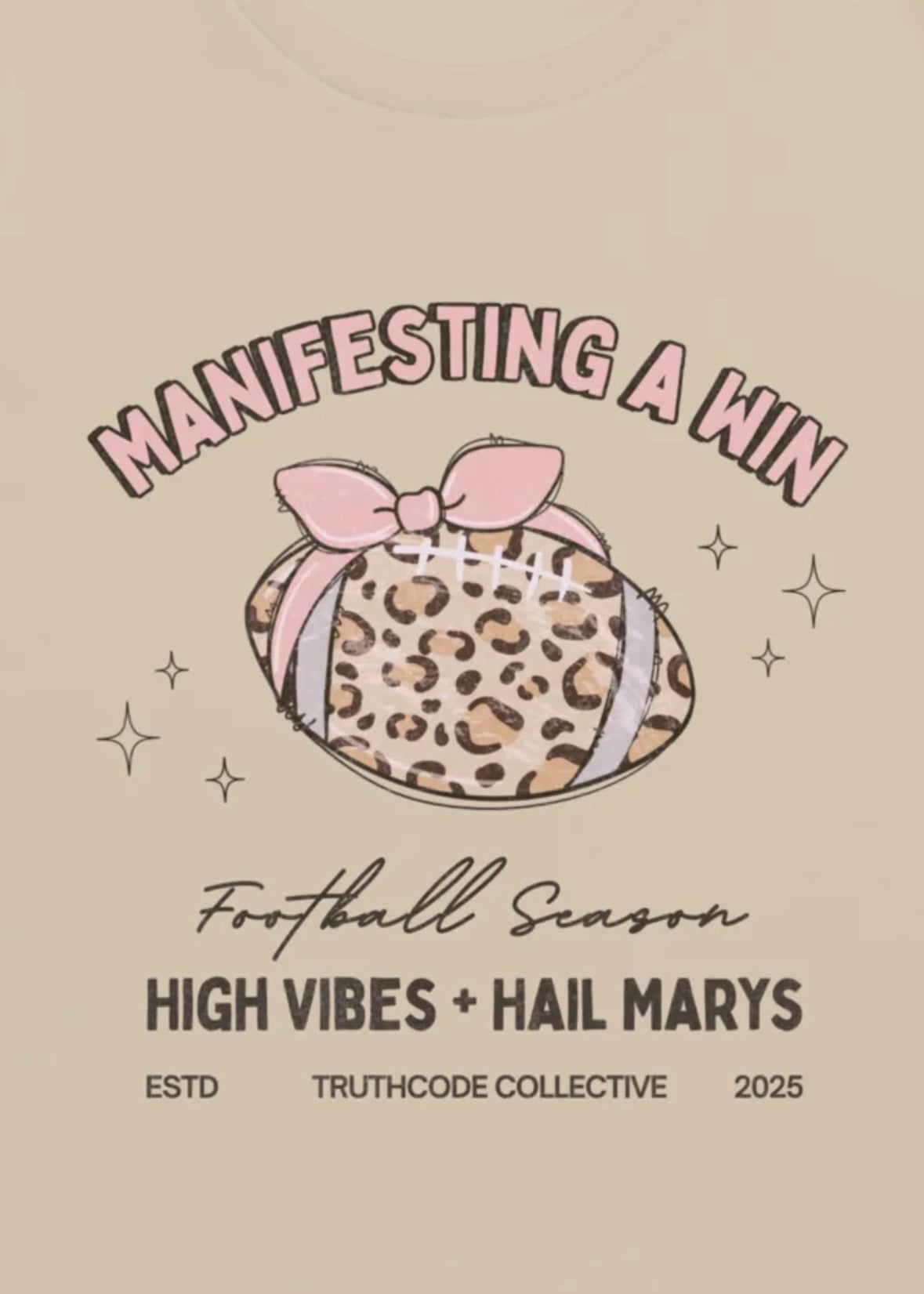 Close view of girly football graphic with a pink bow and text 'Manifesting a win, football season' and 'High vibes and hail marys' 
