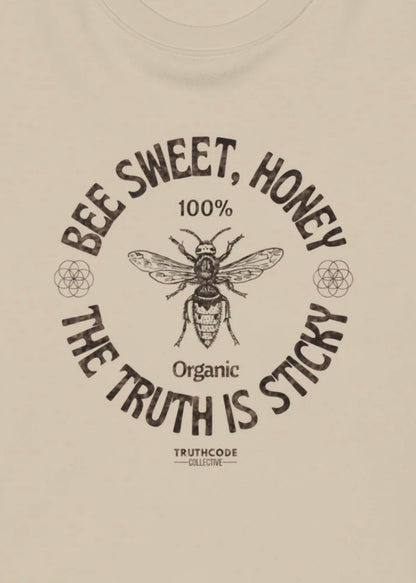 Close view of beige sweatshirt with a bee graphic and text 'Bee sweet, honey. The truth is sticky'