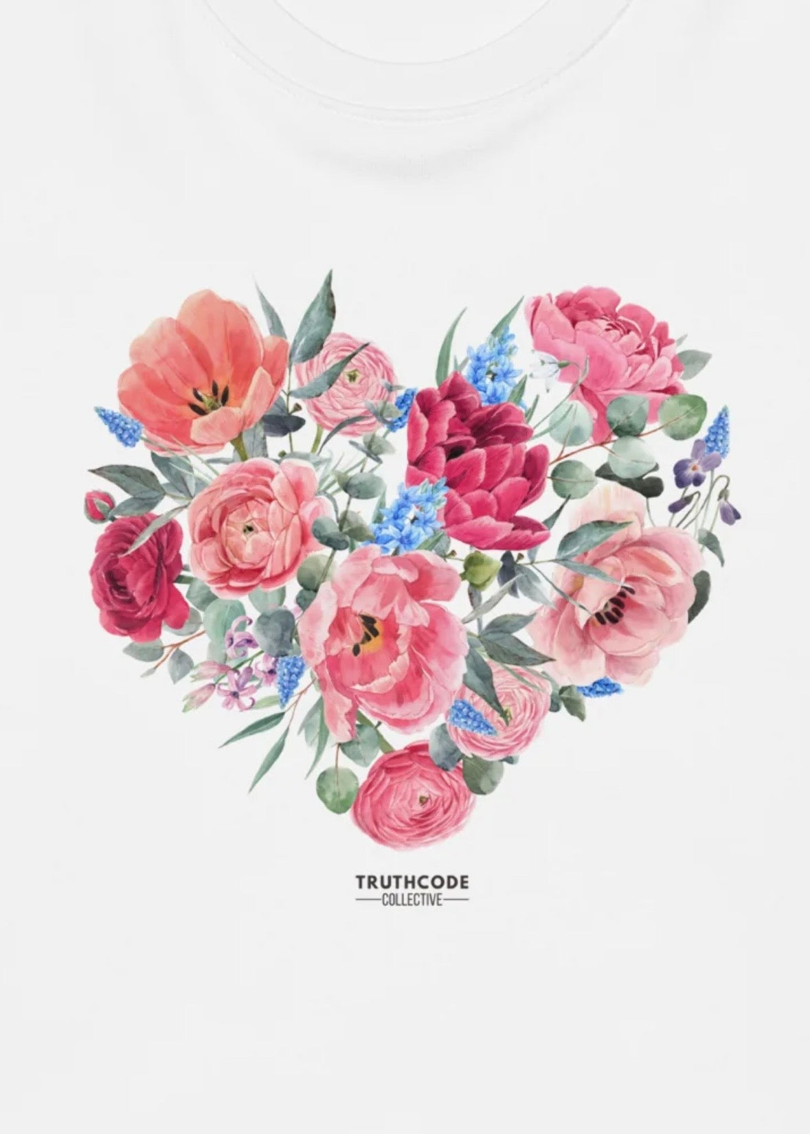 Close view of white sweatshirt with heart-shaped arrangement of pink, red, and blue flowers and green leaves