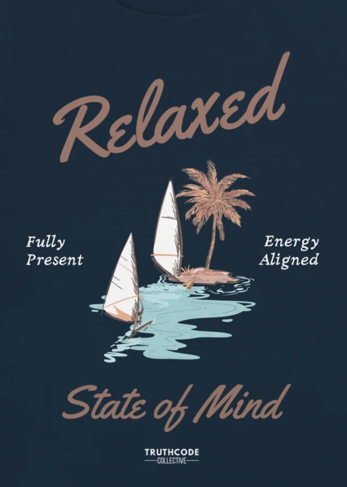 Close view of navy blue t-shirt with sailboat graphic and text 'Relaxed state of mind, energy aligned, fully present' 