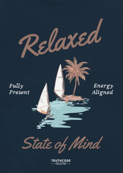 Close view of navy blue t-shirt with sailboat graphic and text 'Relaxed state of mind, energy aligned, fully present' 