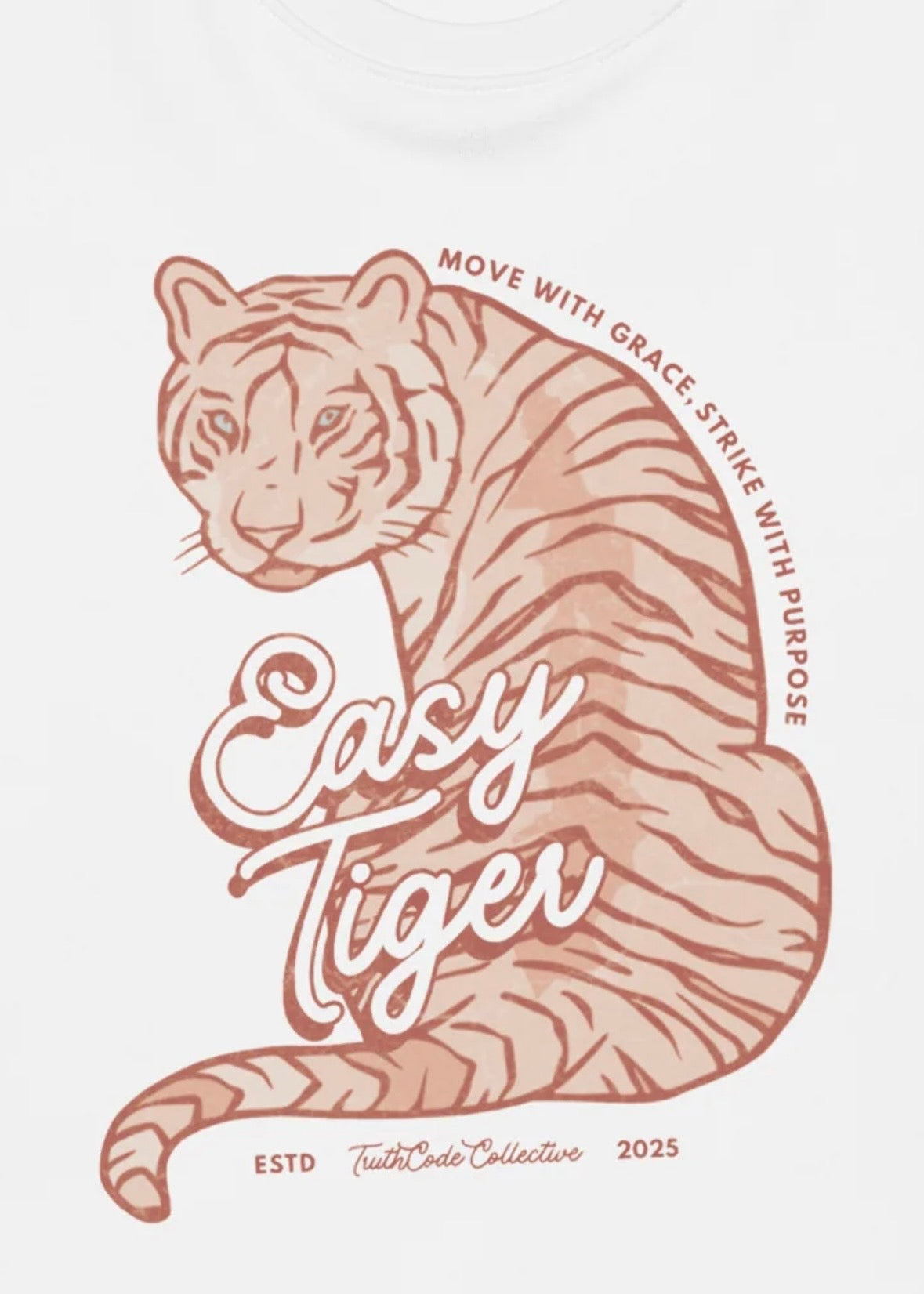 Close view of white sweatshirt with graphic design of a tiger with 'Easy Tiger' and 'Move with grace, strike with purpose' text 