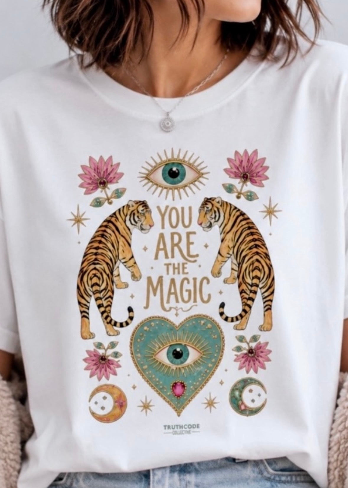 White t-shirt with tiger design and text 'You are the magic' on a white background