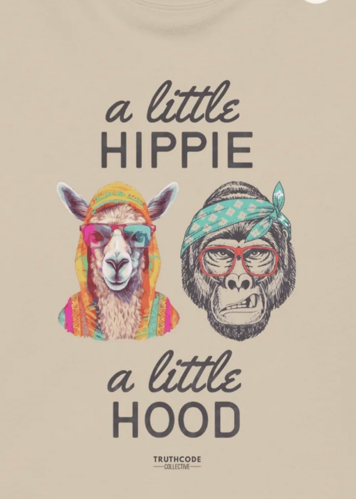 Close view of beige organic sweatshirt with graphic design of colorfully clothed llama and gorilla in a headband with text 'A little hippie, a little hood' on a white background