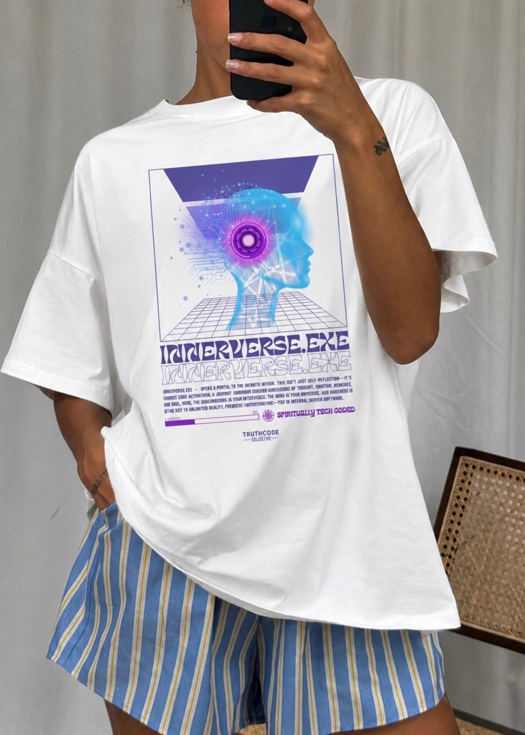 Person wearing a white t-shirt with a cool graphic design and 'Innerverse.exe' text, standing against a neutral background.