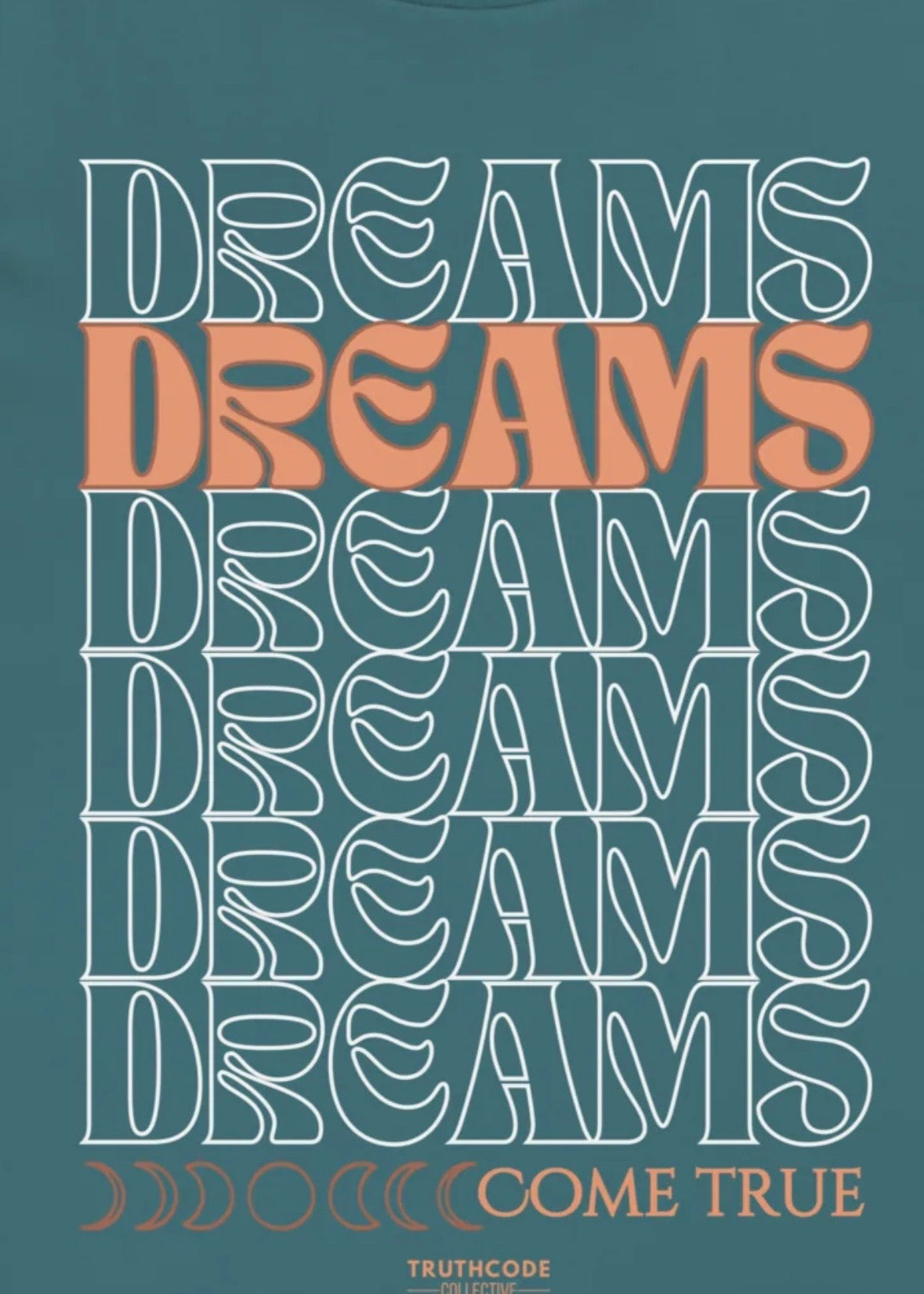 Close view of teal tee with text design 'DREAMS COME TRUE' on a teal background