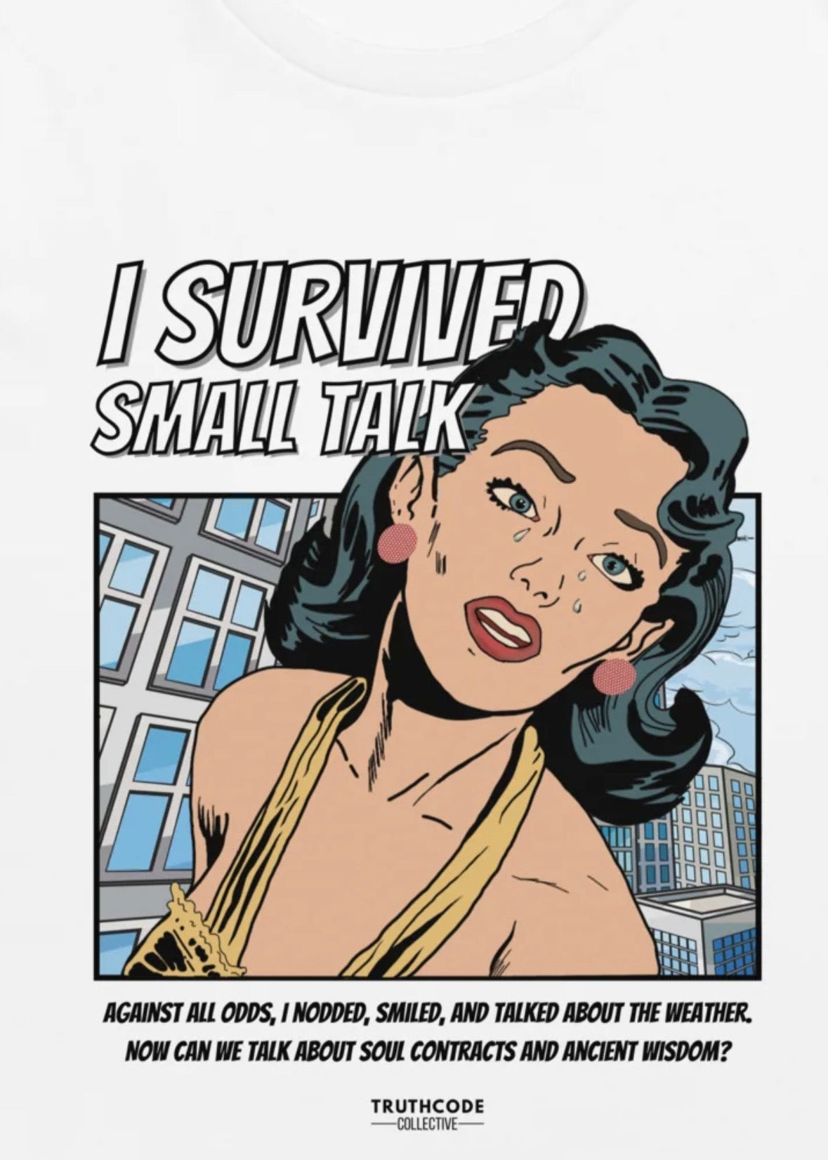 Close view of white tee with cartoon character graphic and humorous text 'I survived small talk, against all odds.' and 'I  nodded, I smiled, and talked about the weather. Now can we talk about soul contracts and ancient wisdom?'