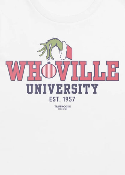Close view of white t-shirt with text design of 'Whoville University' with a Santa suit style sleeve and green hand holding a Christmas ornament