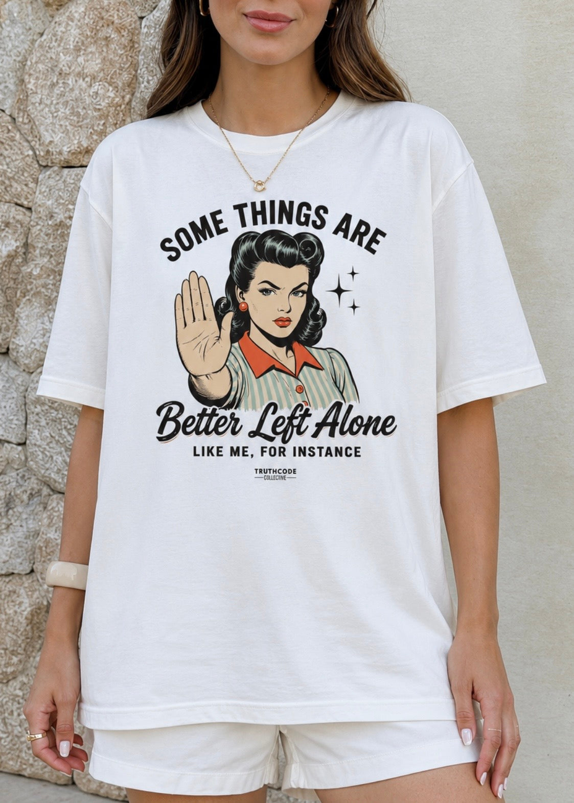 A woman wearing an oversized white graphic t-shirt with a retro-style pin-up illustration and the text 'SOME THINGS ARE Better Left Alone LIKE ME, FOR INSTANCE'.