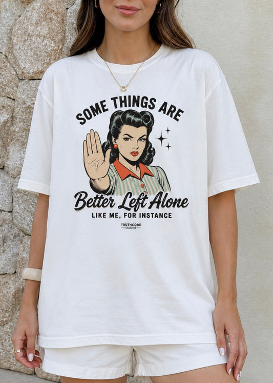 A woman wearing an oversized white graphic t-shirt with a retro-style pin-up illustration and the text 'SOME THINGS ARE Better Left Alone LIKE ME, FOR INSTANCE'.
