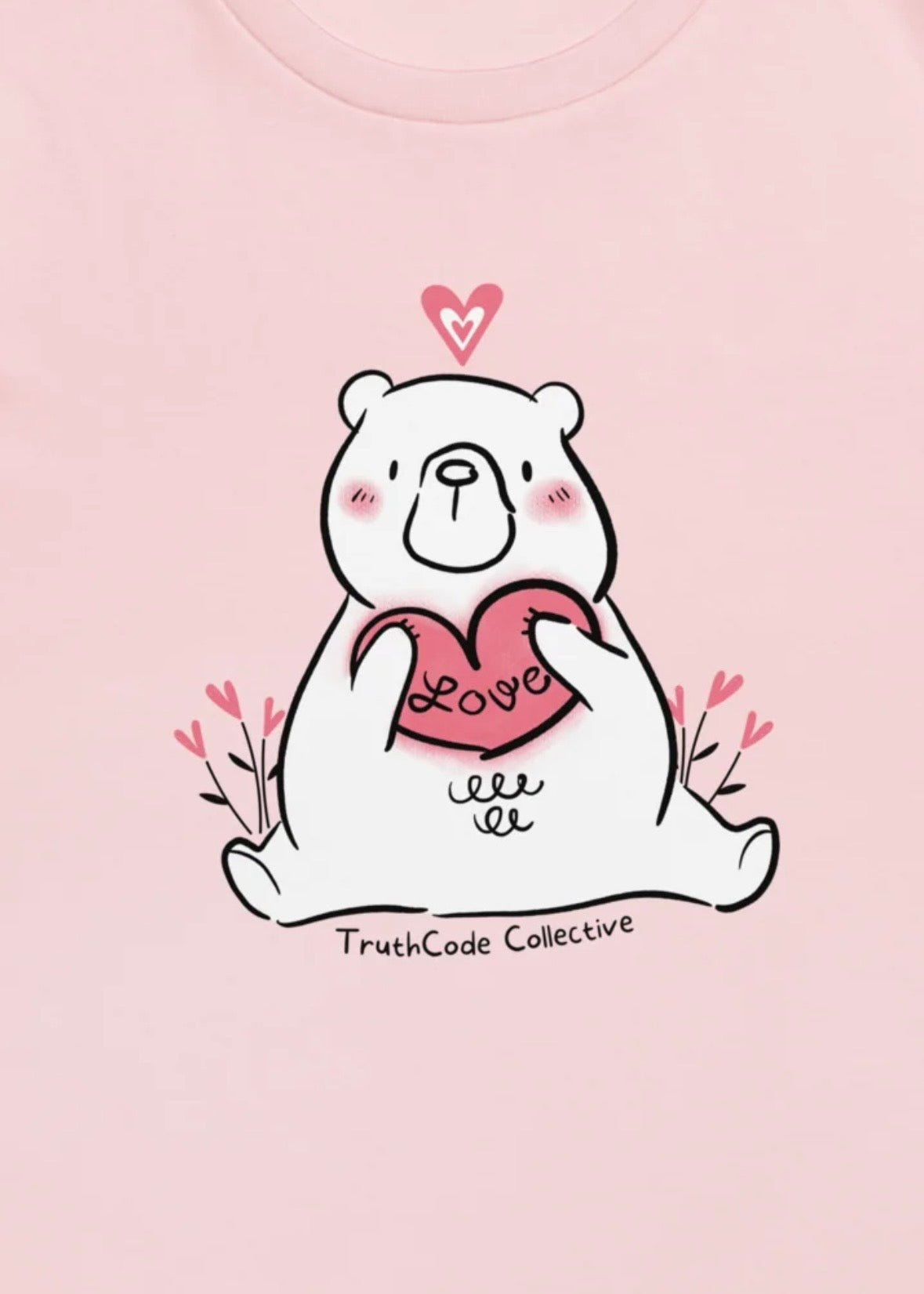 Close view of pink t-shirt with cartoon bear holding a heart with 'LOVE' on a pink background