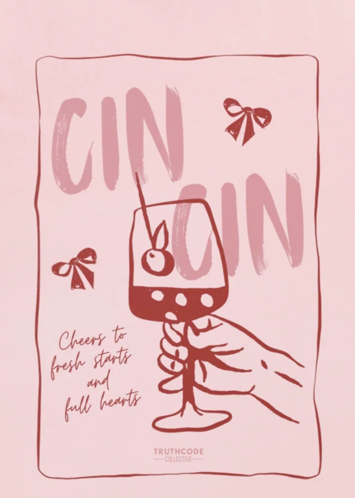 Close view of pink t-shirt with text 'Cin Cin, cheers to fresh starts and full hearts' and graphic of a glass of gin 