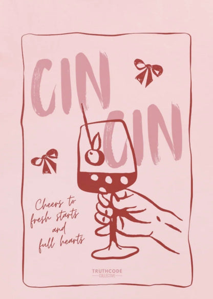 Close view of pink t-shirt with text 'Cin Cin, cheers to fresh starts and full hearts' and graphic of a glass of gin 