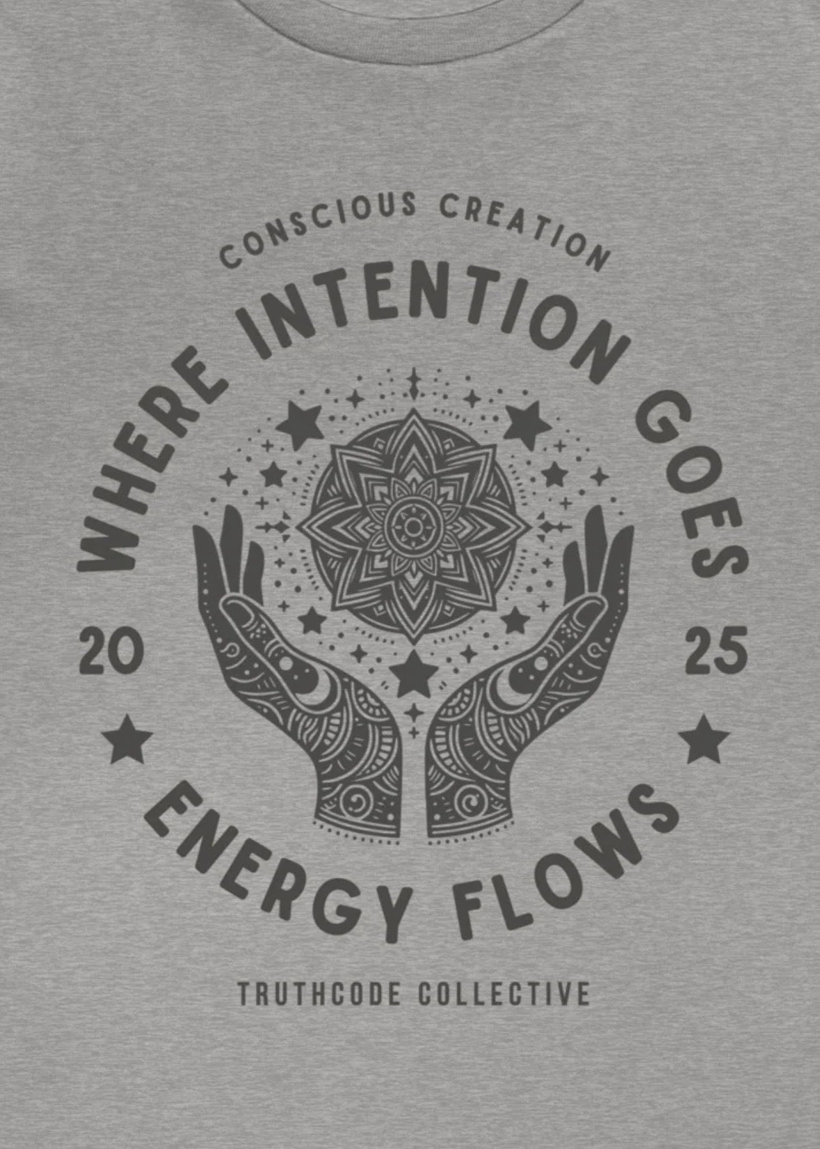 Close view of a gray t-shirt with mandala design and text 'Where intention goes, energy flows' 