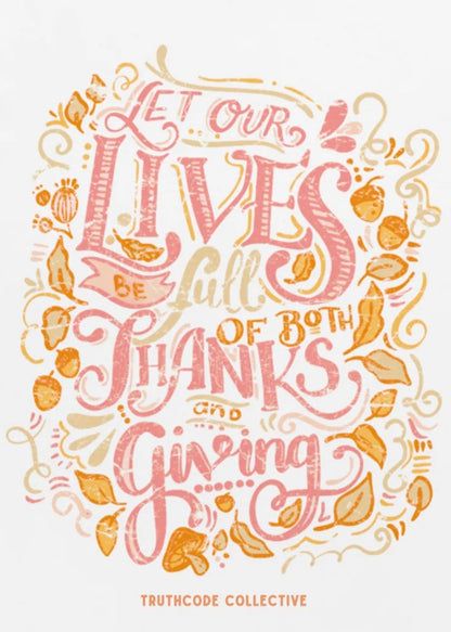 Close view of white t-shirt with decorative text 'Let our lives be full of both thanks and giving' surrounded by autumn elements 