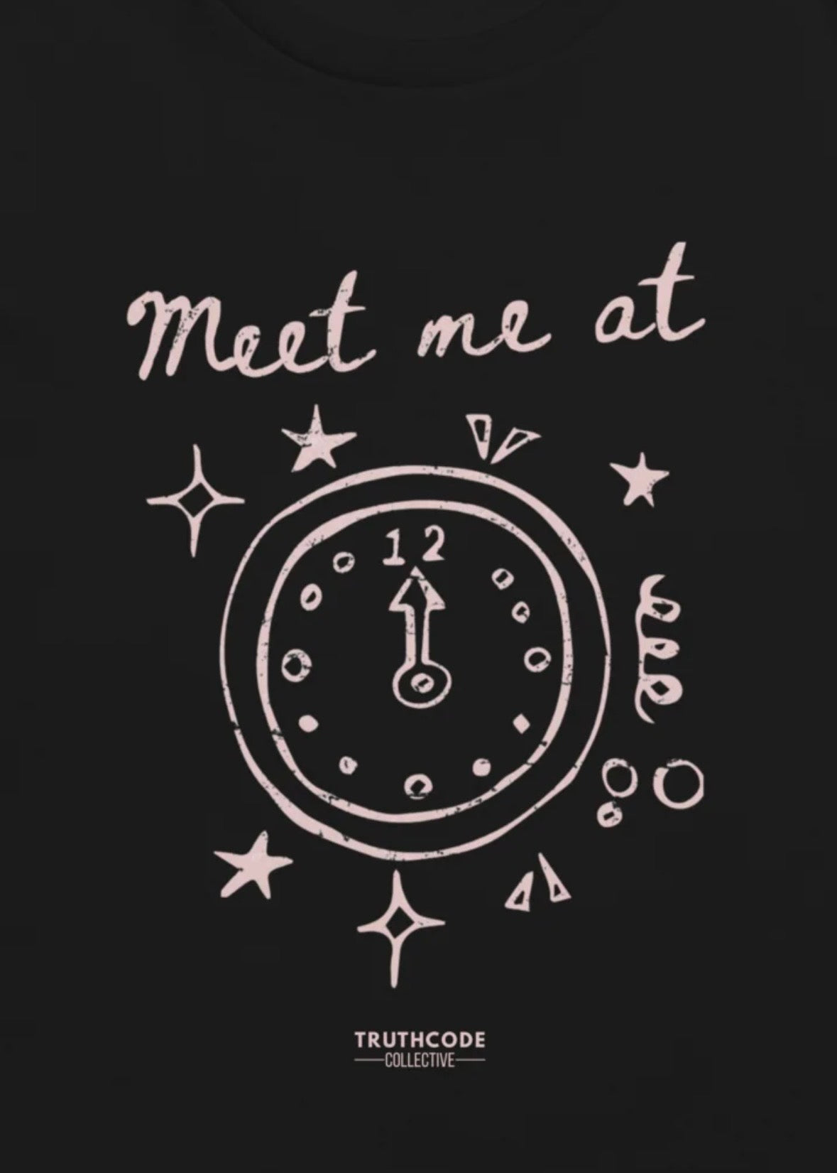 Close view of black t-shirt with white clock design and text 'Meet me at' and the clock showing midnight for the time.