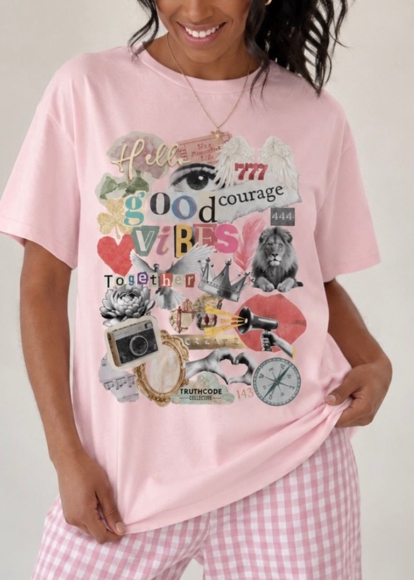 Person wearing a pink manifestation t-shirt with a colorful graphic design on a plain background, Graphics include: 777, heart, camera, compass, lips, mirror, crown, 444, lotus flower and more.