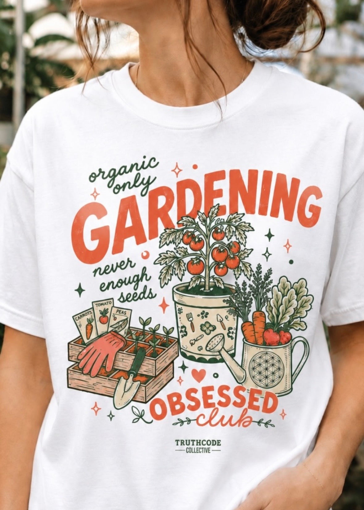 White t-shirt with cute gardening-themed design and text 'organic only', 'Gardening Obsessed Club' and 'never enough seeds' worn by a person.