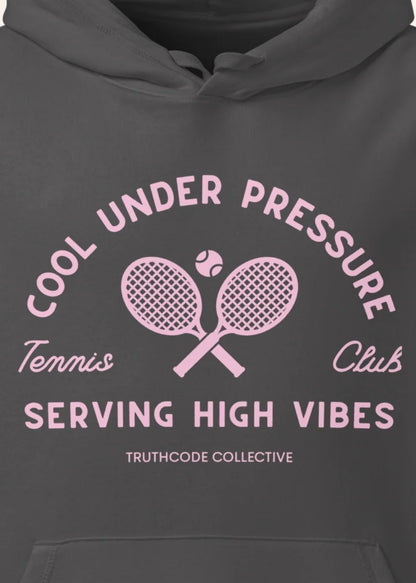 Close view of dark gray organic hoodie with pink and white text 'Cool under pressure, serving high vibes' and tennis graphics on a white background