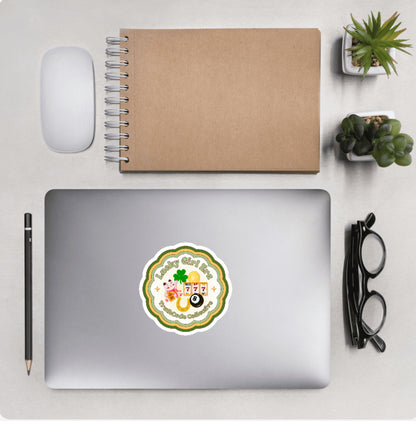 Aerial view of a desktop with laptop showing a circular sticker with text 'Lucky girl era' and design of symbols of luck 