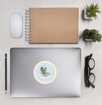 Aerial view of a desktop with laptop showing a circular sticker with design of an angel statue and text 'My love for you echoes through all timelines and dimensions'
