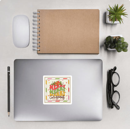Laptop with a 'Merry Merry Christmas' sticker and other desktop accessories around